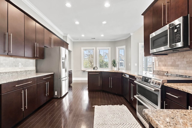 kitchen featuring dark wood finished floors, appliances with stainless steel finishes, crown molding, light stone countertops, and dark brown cabinets