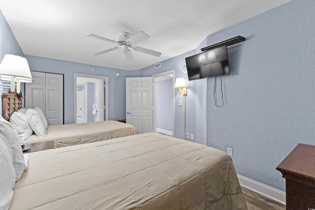2007 S Ocean Blvd Unit 2006, Myrtle Beach, SC 29577 - bedroom featuring wood finished floors, a ceiling fan, ensuite bathroom, a textured wall, and a closet