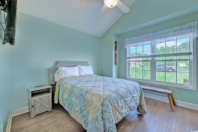 bedroom featuring lofted ceiling, a ceiling fan, baseboards, and wood finished floors