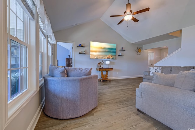 living area with ceiling fan, high vaulted ceiling, wood finished floors, and baseboards