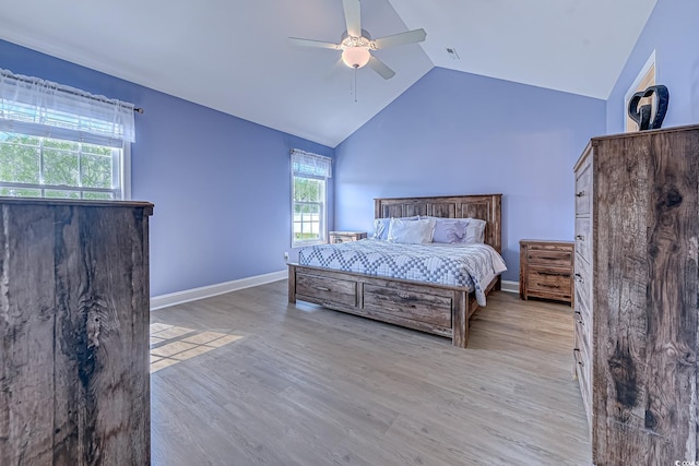 bedroom with visible vents, a ceiling fan, vaulted ceiling, baseboards, and light wood finished floors