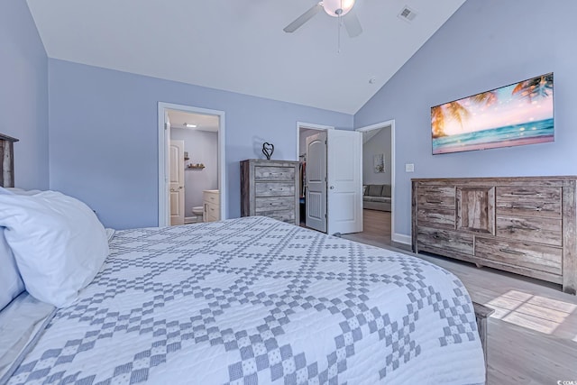 bedroom featuring visible vents, a ceiling fan, wood finished floors, ensuite bathroom, and high vaulted ceiling