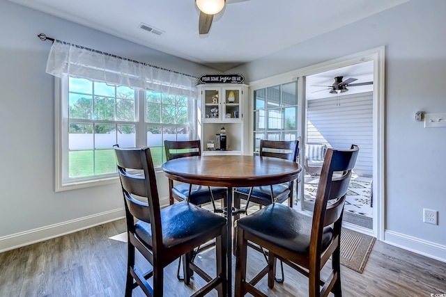 dining space featuring a ceiling fan, visible vents, and wood finished floors