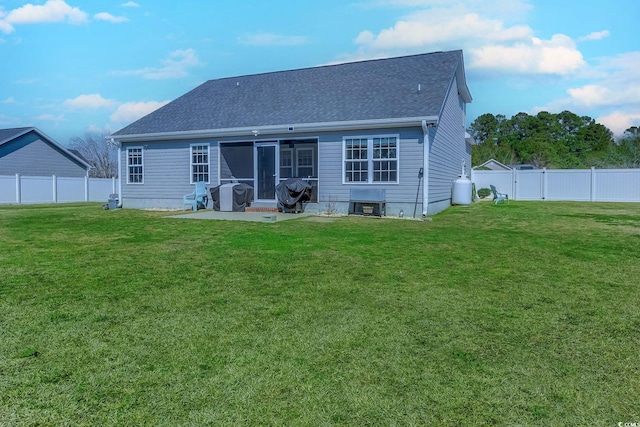 rear view of property featuring a patio, a lawn, a fenced backyard, and roof with shingles