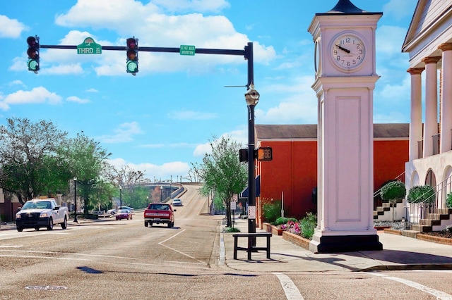 view of road with street lighting, traffic lights, curbs, and sidewalks