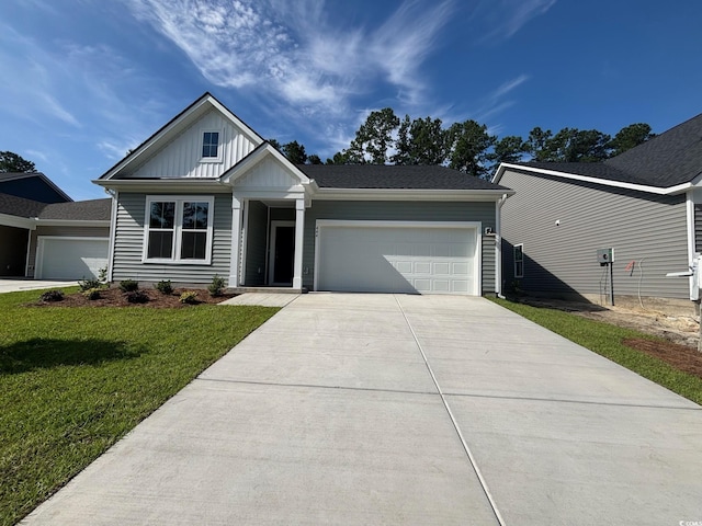 444 Sun Colony Blvd, Longs, SC 29568 - view of front of home with a garage, driveway, board and batten siding, and a front lawn