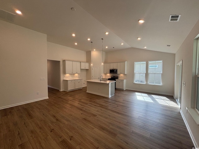 444 Sun Colony Blvd, Longs, SC 29568 - kitchen featuring stainless steel microwave, open floor plan, a kitchen island with sink, lofted ceiling, and white cabinets