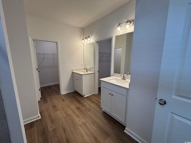 444 Sun Colony Blvd, Longs, SC 29568 - bathroom featuring wood finished floors, two vanities, and a spacious closet
