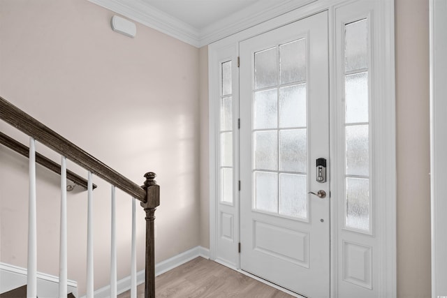 entrance foyer with baseboards, light wood finished floors, stairway, and crown molding