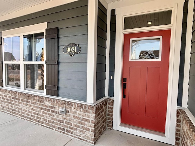 property entrance featuring brick siding