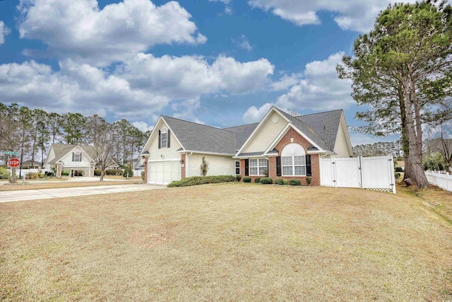 view of front facade featuring concrete driveway, a gate, fence, a front lawn, and brick siding