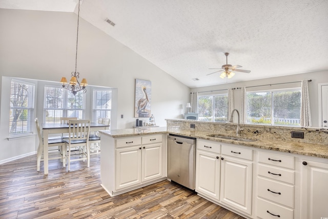 kitchen featuring lofted ceiling, visible vents, light wood-style floors, a sink, and dishwasher