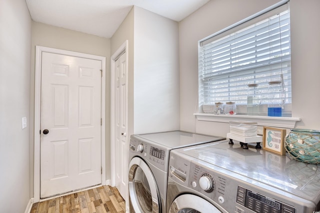 laundry area featuring laundry area, separate washer and dryer, and light wood-type flooring