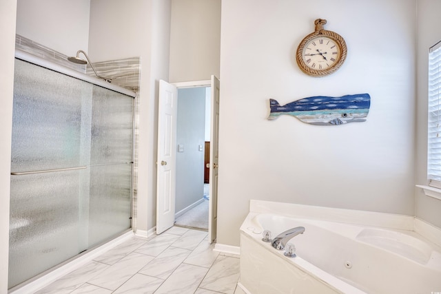 bathroom with a stall shower, a tub with jets, marble finish floor, and baseboards