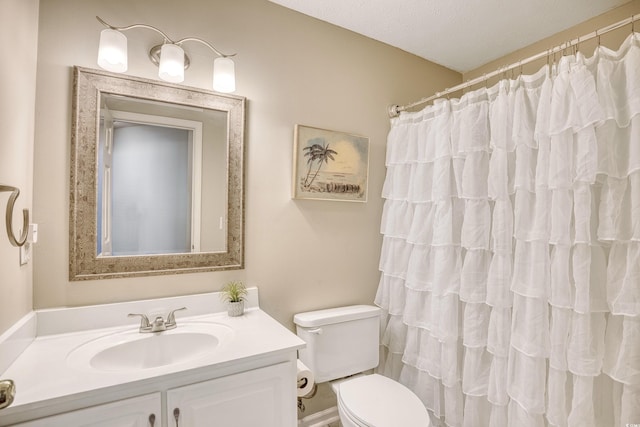 bathroom featuring toilet, a shower with curtain, and vanity