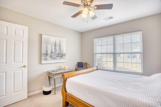 bedroom featuring a textured ceiling, ceiling fan, carpet floors, visible vents, and baseboards