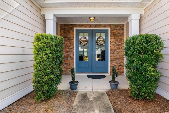 entrance to property featuring french doors and stone siding