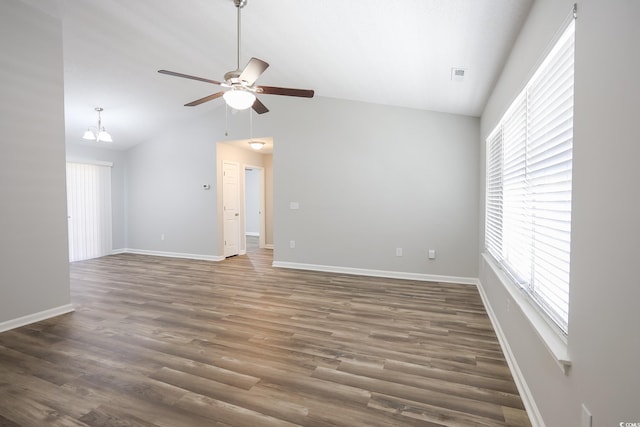 spare room with lofted ceiling, wood finished floors, a wealth of natural light, and a ceiling fan