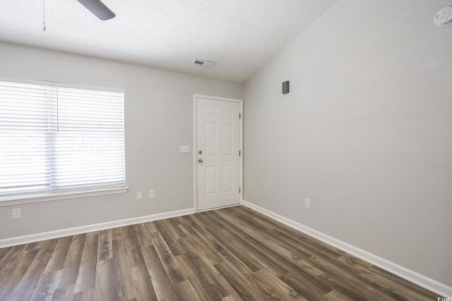 unfurnished room featuring baseboards, visible vents, ceiling fan, wood finished floors, and a textured ceiling