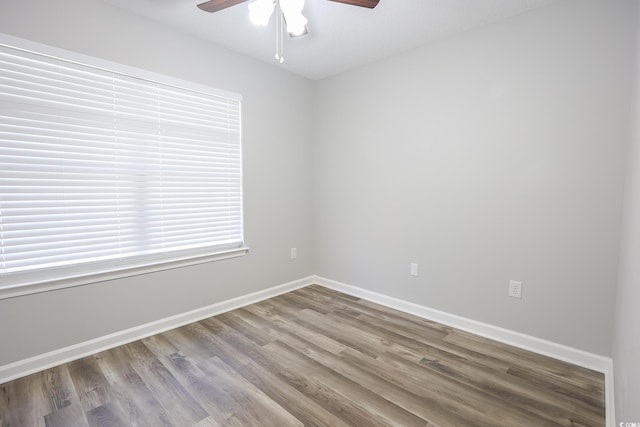 spare room featuring a ceiling fan, baseboards, and wood finished floors