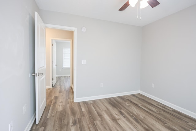 unfurnished room with ceiling fan, baseboards, and wood finished floors