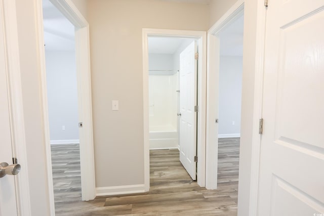 hall with baseboards and wood finished floors