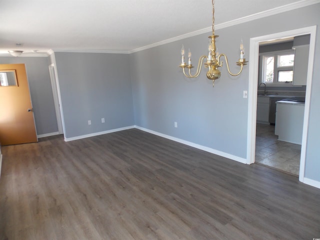 spare room with a sink, ornamental molding, dark wood finished floors, and baseboards