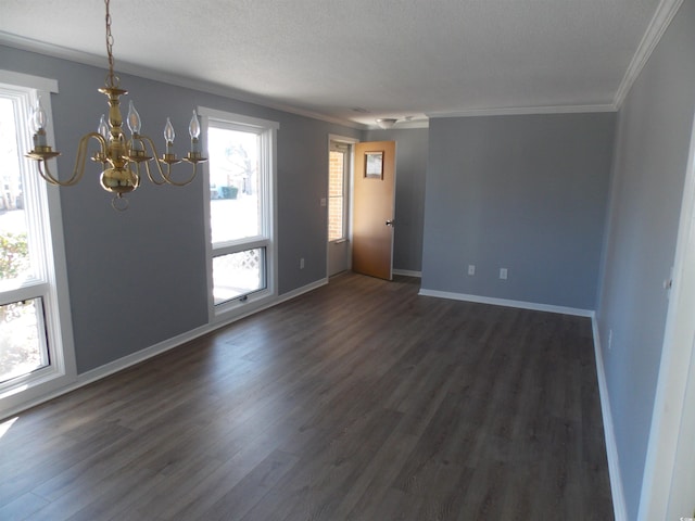 unfurnished room featuring dark wood-type flooring, ornamental molding, a textured ceiling, a chandelier, and baseboards