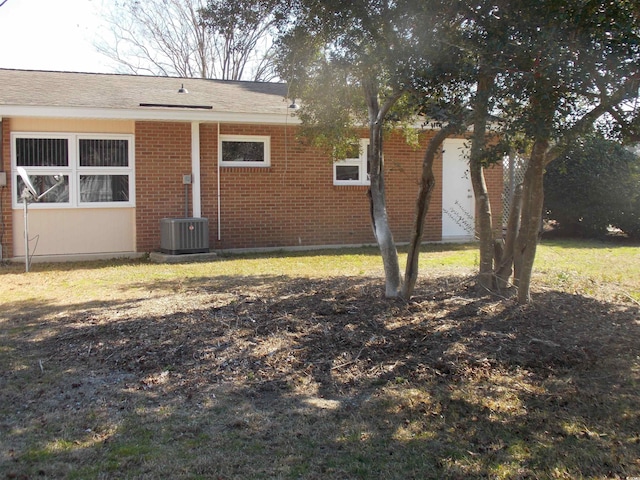 view of side of property with brick siding and central AC unit