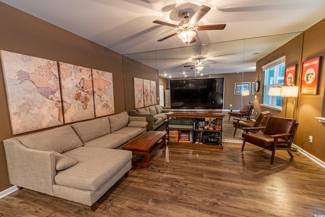 living area featuring a ceiling fan, baseboards, and wood finished floors