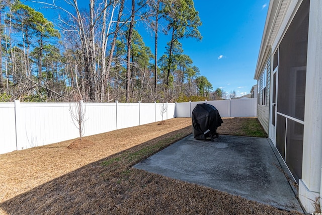 view of yard with a patio area, a fenced backyard, and a sunroom