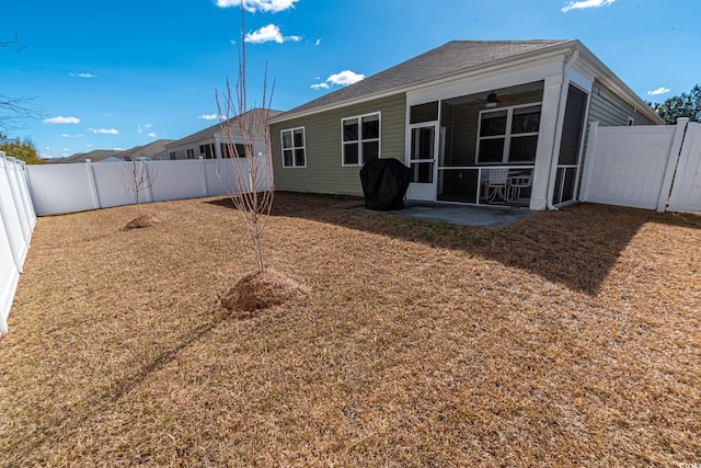 back of house with a fenced backyard and a sunroom