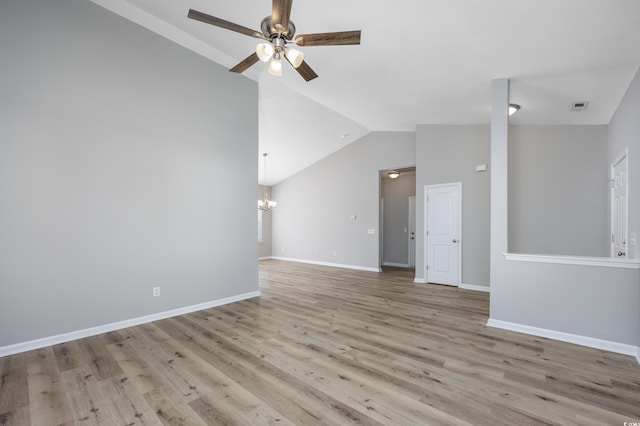 unfurnished room featuring visible vents, baseboards, vaulted ceiling, ceiling fan with notable chandelier, and wood finished floors