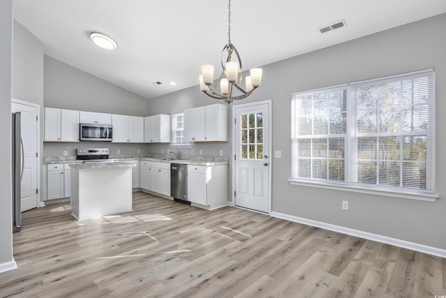 kitchen featuring visible vents, a sink, stainless steel appliances, white cabinets, and light wood finished floors