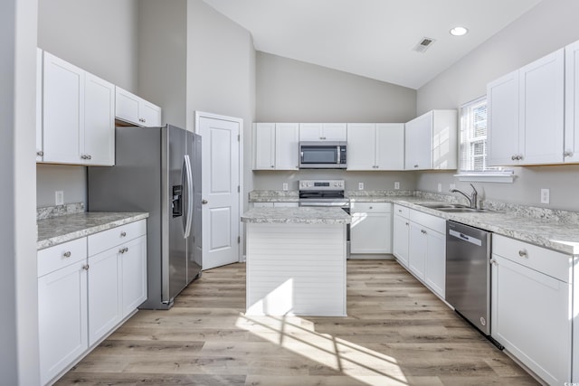 kitchen featuring visible vents, white cabinetry, stainless steel appliances, and a sink