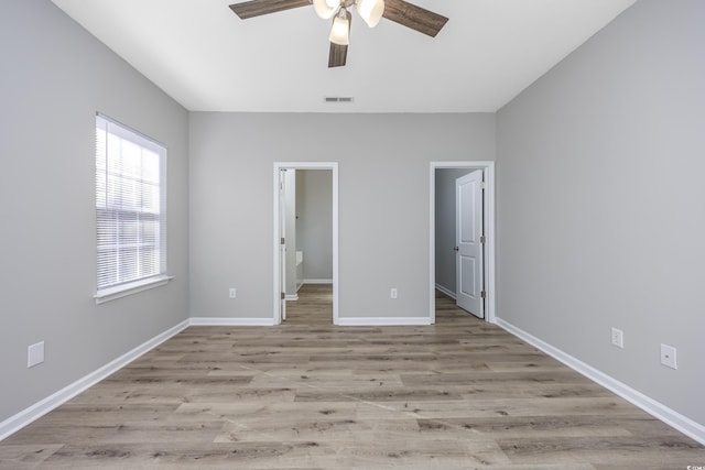 unfurnished bedroom featuring visible vents, baseboards, wood finished floors, and a spacious closet