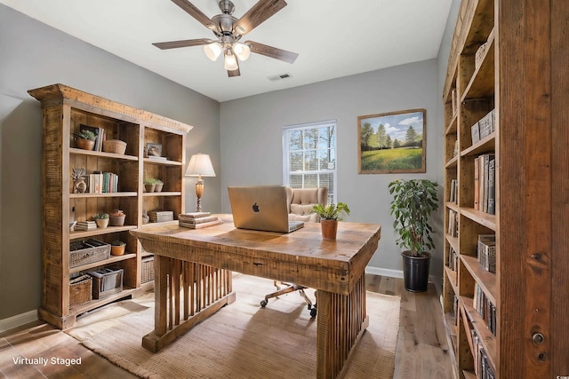 office area featuring visible vents, light wood-style flooring, baseboards, and ceiling fan