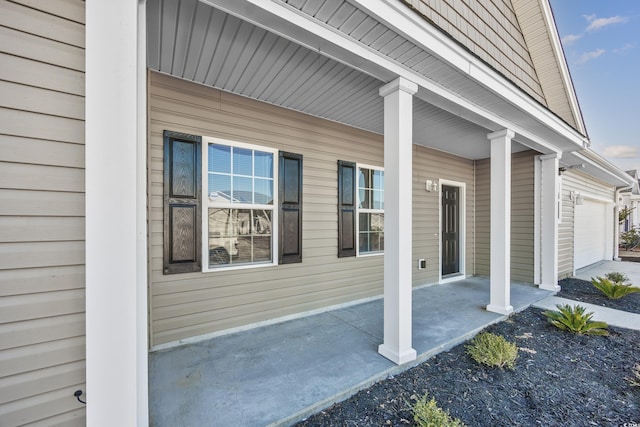 doorway to property with a garage and a porch