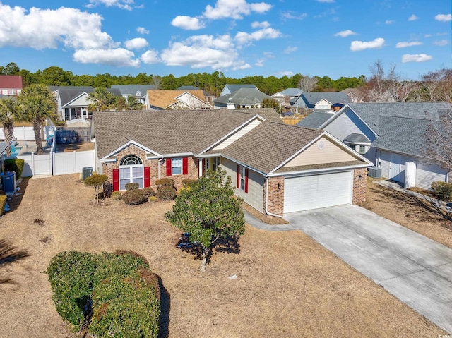 ranch-style house featuring fence, an attached garage, a residential view, concrete driveway, and brick siding