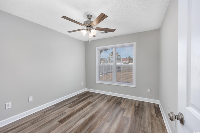 empty room with dark wood finished floors, a textured ceiling, a ceiling fan, and baseboards