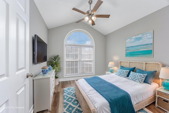 bedroom featuring lofted ceiling, wood finished floors, and a ceiling fan