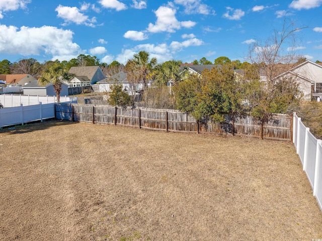 view of yard with a fenced backyard and a residential view