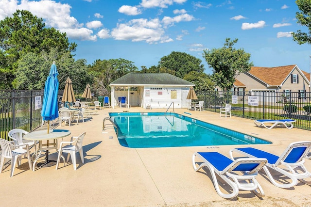 community pool with a patio area and fence