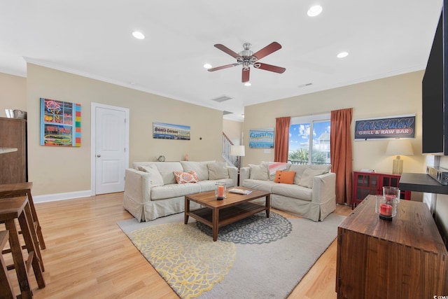 living room with crown molding, recessed lighting, visible vents, stairway, and light wood-style floors