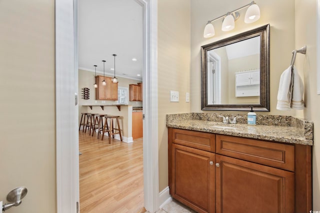 bathroom with vanity, baseboards, and wood finished floors