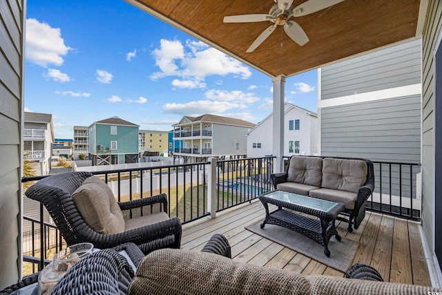 wooden deck featuring a ceiling fan, a residential view, and an outdoor living space