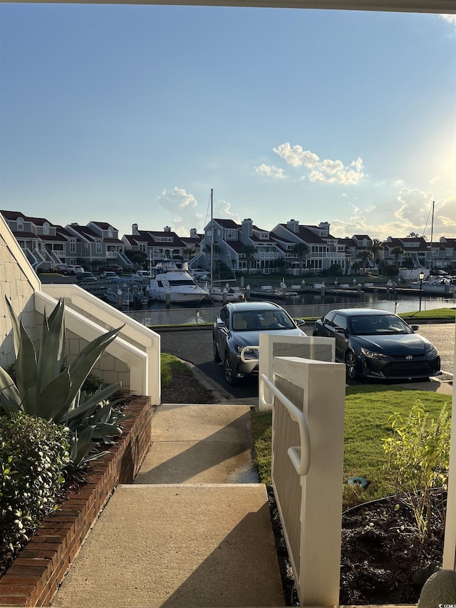 view of yard with a water view, a residential view, and a boat dock