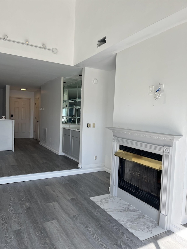 4396 Baldwin Ave Unit 141, Little River, SC 29566 - unfurnished living room featuring wood finished floors, a fireplace with flush hearth, and baseboards