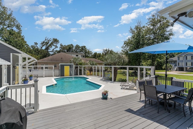 view of swimming pool featuring a fenced in pool, fence, a wooden deck, area for grilling, and outdoor dining area