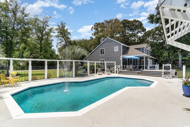 view of pool with a patio area, a sunroom, and fence